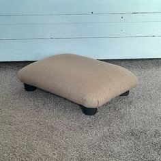 a footstool sitting on the floor in front of a wall