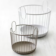 two wire baskets sitting on top of a white table