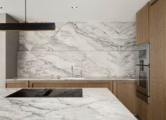 a kitchen with marble counter tops and wooden cabinets