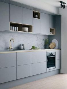 a kitchen with gray cabinets and white counter tops