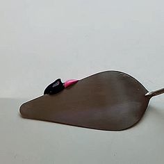 a spoon that has some kind of food on top of it with a pink handle