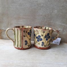 two coffee mugs sitting next to each other on a table