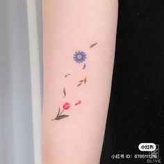 a woman's arm with a flower tattoo on the back of her left arm