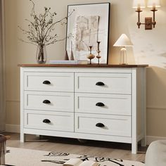 a white dresser sitting in a living room next to a window