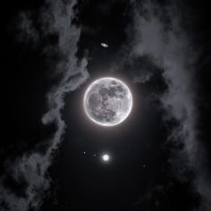 the moon and two planets are seen in the night sky, with clouds around them