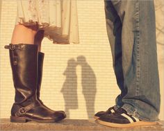 two people standing next to each other wearing boots