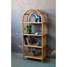 a bamboo shelf with books and plants on it