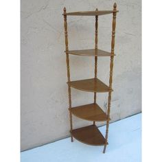 three tiered wooden shelf against a white wall