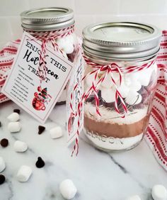 two mason jars filled with marshmallows and chocolate