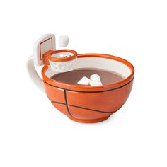 an orange and white basketball mug with ice cubes in it's rim is shown