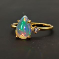 Natural Pear Opal Ring-Fire Opal Ring-Stackable Ring-Dainty Ring-Sterling Silver Ring-14k Gold Ring-October Birthstone Ring-Gift For Her - About Ring Gemstone = Natural Ethiopian Opal   Gemstone Size = 7x9mm   (Approx.) Gemstone Shape = Pear Cabochon Secondary Stone - Cubic Zirconia (Note - Please Contact for the Real Genuine Earth Mined Diamond in ring) ----------------------------------------------------------------------------------------------------------------------------------------------- Pear Opal Ring, Dainty Opal Ring, Opal Stone Ring, Gold Opal Ring, Fire Opals, October Birthstone Rings, Silver Opal Ring, Zierlicher Ring, Fire Opal Ring