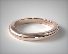 two gold wedding bands with the word love written on each side, in front of a white background