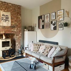 a living room filled with furniture next to a fire place and a brick wall in the background