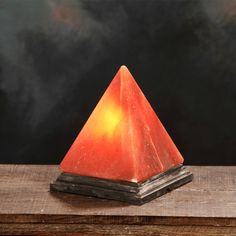 an orange triangle shaped light sitting on top of a wooden table