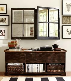 a living room with pictures on the wall and a dresser in front of an open window