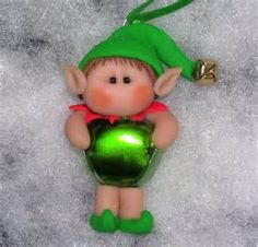 a green glass ornament with a little elf holding a ball