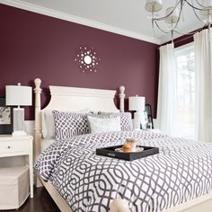 a bedroom with purple walls and white furniture