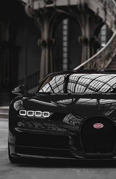 the black bugatti is parked in front of some stairs