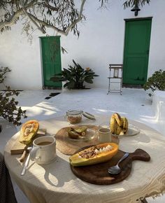 a table topped with bananas and other foods on top of a wooden cutting board next to a potted plant