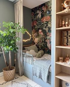 a small child's room with a bed, bookshelf and potted plant