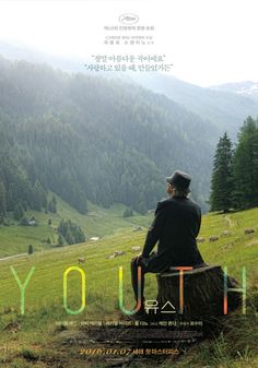 a man sitting on top of a tree stump in front of a lush green hillside