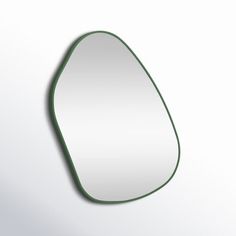 an oval shaped mirror with green trim on a white wall, reflecting the light from below