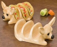 two ceramic dogs with tacos on their heads are sitting next to vegetables and peppers