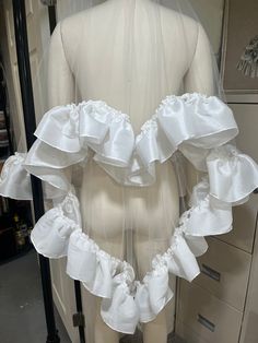 the back of a mannequin's torso with white ruffles on it