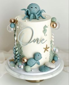 a one tiered cake decorated with an octopus and other sea creatures is on a plate