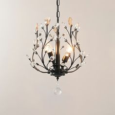 a chandelier hanging from a chain with clear crystal drops on the top and bottom