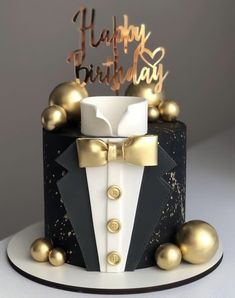 a black and white birthday cake with gold decorations