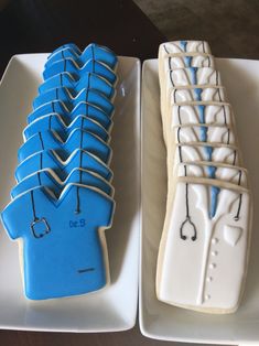 two decorated cookies in the shape of toothbrushes on trays next to each other