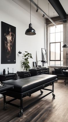 an industrial style living room with black leather couches and art work on the wall