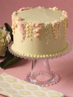 a white cake with pink flowers on it and the words buttercream decorating