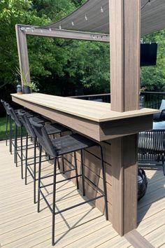 an outdoor bar with chairs and tables on a deck