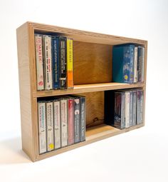 a wooden book shelf filled with lots of books next to a wall mounted cd player