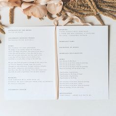 an open book sitting on top of a table next to dried flowers and petals,