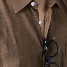 a close up of a pair of black scissors on a person's shirt with buttons