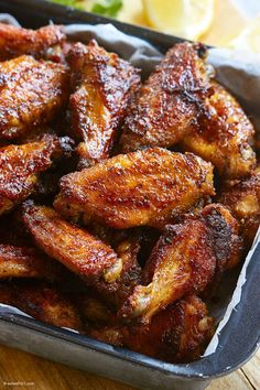 some chicken wings are in a tin on a table