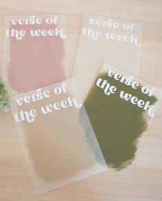 three pieces of paper with words on them sitting on a table next to a plant