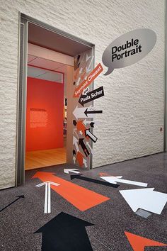 an entrance to a building with multiple directional signs on the floor and arrows pointing in different directions