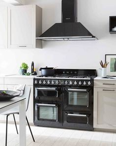 a black stove top oven sitting inside of a kitchen next to a dining room table