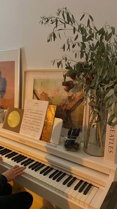 a woman sitting at a piano playing the music on it's own side,