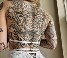 the back of a woman with tattoos on her body