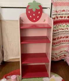 a pink book shelf with a strawberry on top