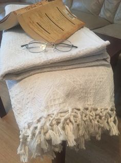 a pair of glasses sitting on top of a white blanket next to a wooden table