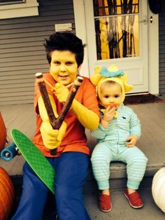 two children sitting on the front steps with their halloween costumes