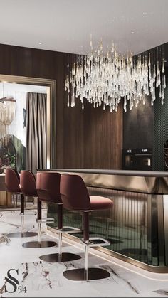 an elegant bar with chandelier hanging from the ceiling and red chairs around it