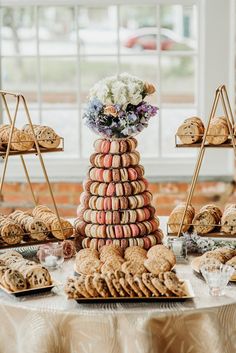 a table topped with lots of cookies and crackers next to a vase filled with flowers