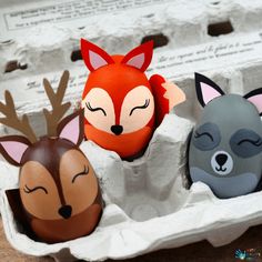 an egg carton with three different animal heads in it, and one is laying down